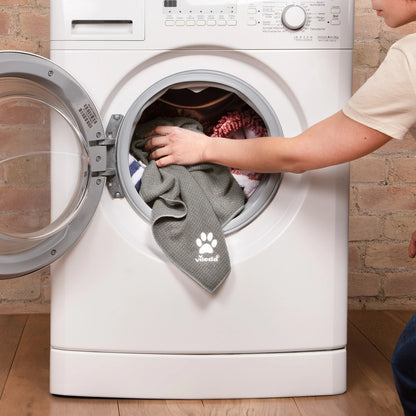 Das graue Vileda Pet Pro Microfaser-Handtuch XL wird in eine Waschmaschine gelegt.