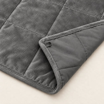 Umgeschlagene Ecke der grauen WOLTU Gewichtsdecke zeigt die weiche Mikrofaserseite und die glattere Polyesterrückseite.